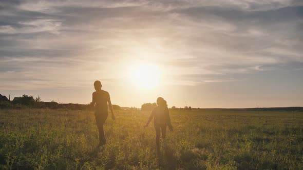 A Guy and a Girl Launch a Paralon Plane at Sunset.