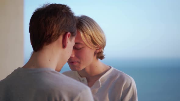 Lovely gay couple rubbing noses on the balcony