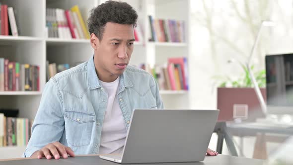 Young African American Man Disappointed By Loss on Laptop