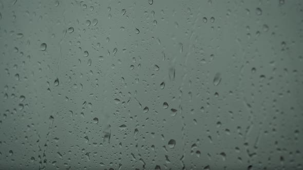 Close Up of a Glass with Water Drops While Outside Is Raining. Drops of Rain Through Glass.