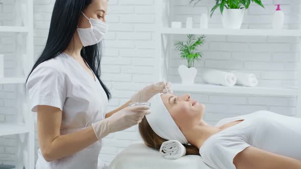 Smiling Woman Doing Procedure for Moisturizing Face