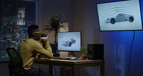 Young Man Sitting Back and Editing an Image on His Computer