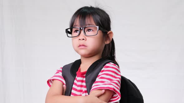 Cute little girl wearing glasses, she nice-looking, charming and enjoying a good mood on white