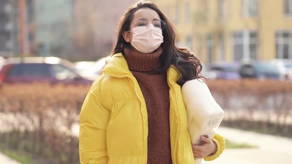 Woman with face mask walking at the street. 