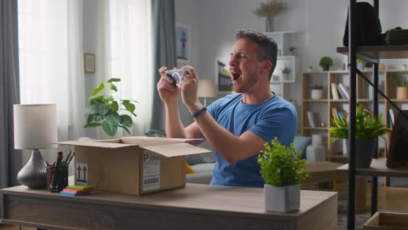 Handsome Young Man Takes Out a Game Console From a Cardboard Box