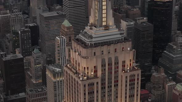 AERIAL: Close Up of Empire State Building at Dusk with Lights on 