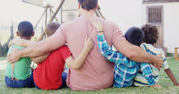 Man with kids sitting in the backyard of house 4k