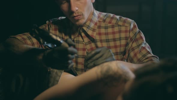 Shot of Tattoo Artist in Creation. The Professional Master Does the Tattoo for Hipster Woman or Girl