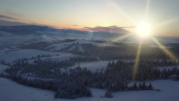 Flight Over Carpathian Mountains in Winter at Sunrise. Rural Landscape in Winter From a Height