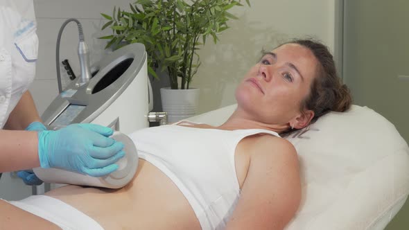 Mature Woman Enjoying Endospheres Hardware Massage at Beauty Clinic