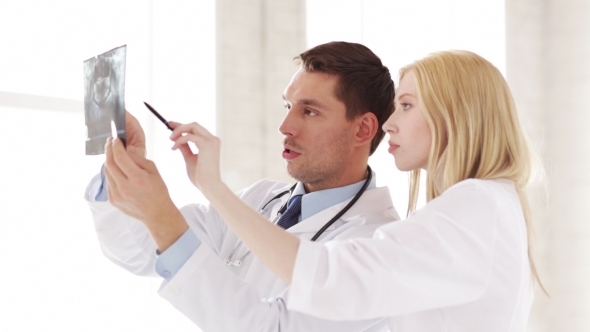 Two Doctors Discussing X-ray Image At Hospital