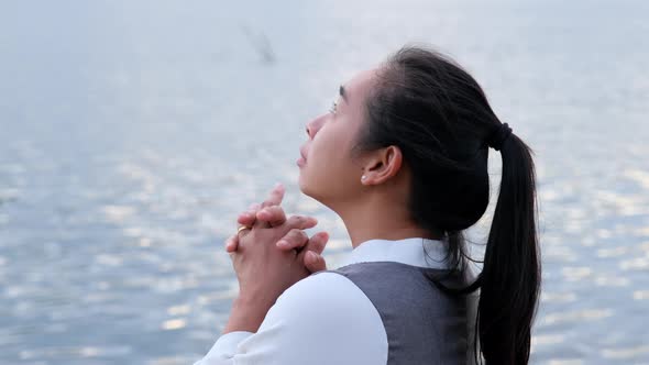 Woman praying alone at sunset. Woman pray for god blessing to wishing have a better life.