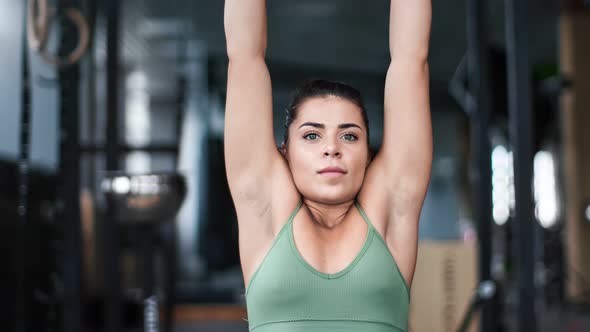 Mixed Race Athletic Woman Pull Up on Wooden Gymnastics Rings