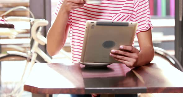 Smiling woman with tablet drinking coffee 4k