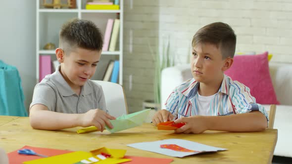 Little Boys Making Origami Boats in Art Class alt