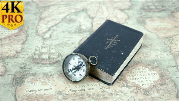 A Compass and a Book on a Map alt
