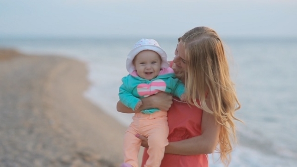Young Mother Holding Baby In Her Arms While