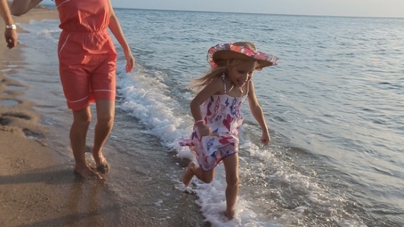 Little Carefree Girl Running Along The Beach To