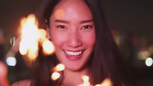 Young asian woman with sparklers is dancing and celebrating a new year. Fireworks,