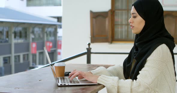 Woman in hijab using laptop 4k