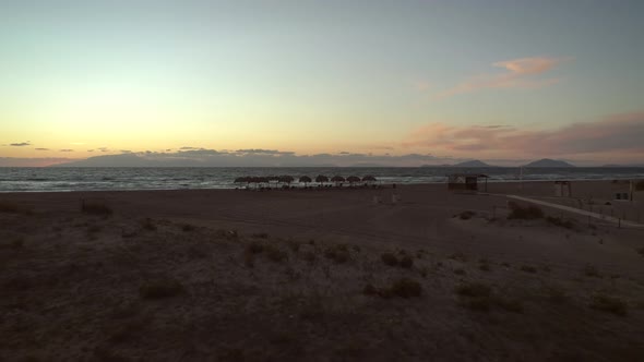 Aerial view of a empty sandy beach at sunset in Greece.