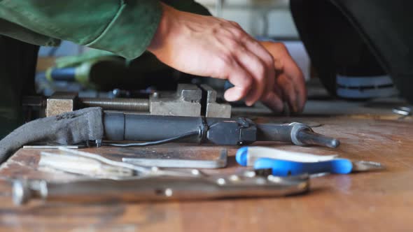 Close Up of Male Arms of Mechanic Taking and Examining Some Vehicle Detail at Workshop