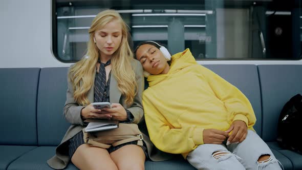 Girl Falls Asleep in Modern Metro Train and Falls on a Woman's Shoulder