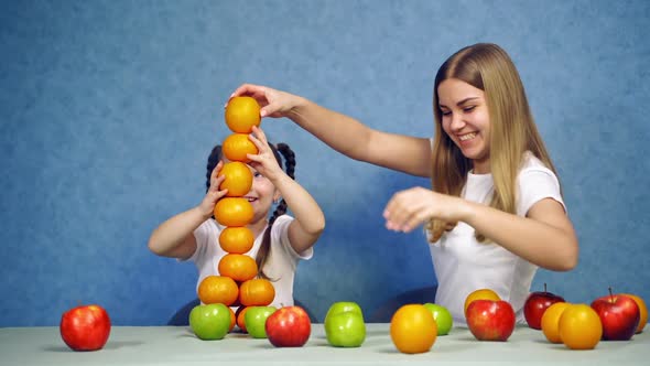 Child girl with fruits. Little cute child girl funny play construct with organic fruits