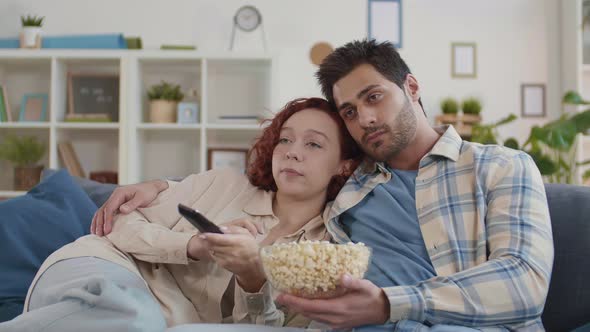 Romantic Couple Cuddling and Eating Popcorn