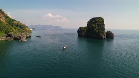 aerial drone approaching a thai longtail boat in the middle of the Andaman Sea of Krabi Thailand bet