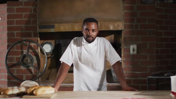 Animation of happy african american male baker smiling at camera in bakery