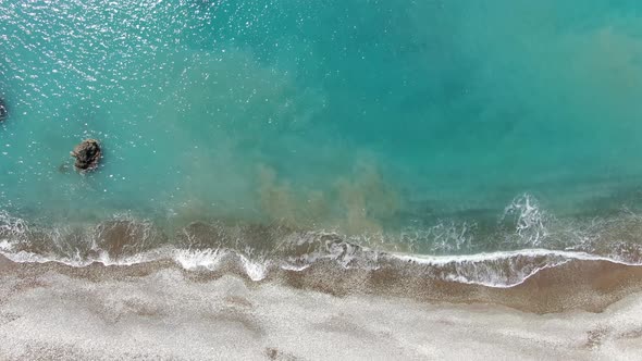 Top View of Turquoise Mediterranean Sea Waters Rolling on Pebbles. Aerial View of Transparent Foamy