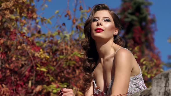 A Sexy Girl in an Evening Dress Walks in an Autumn Park in Warm Weather.