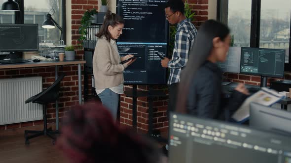 Team of Database Admins Analyzing Source Code on Wall Screen Tv Comparing Errors Using Digital