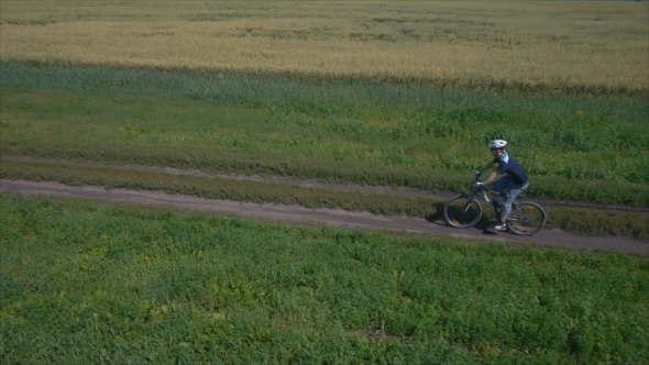 Man Cycling On a Rural Road. Aerial View.