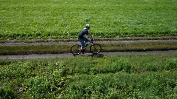 Man Cycling On a Rural Road. Aerial View.