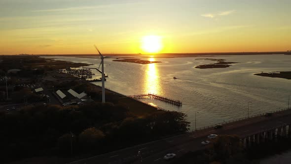 An aerial drone shot over a quiet marshland with a bridge. The drone camera truck left, dolly out wh