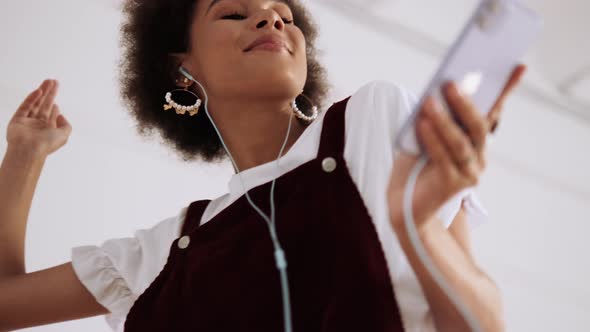 A bottom view of a happy woman dancing while enjoying the music