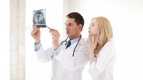 Two Doctors Discussing X-ray Image At Hospital