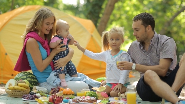 Cheerful Family Having Picnic With Fruits