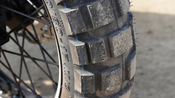 Close-up of a motorcycle wheel on a sandy beach. 4K motorcycle video