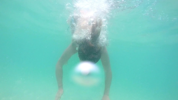 Female Swimming Underwater In Sea