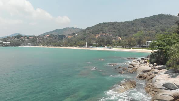 Rocky shoreline Cliff splitting Had Karon Noi Beach from Karon Beach in Phuket, Thailand