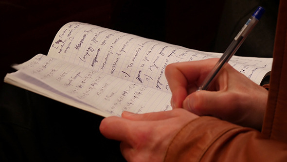 College Student Taking Notes While Studying