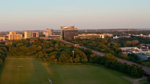 rising drone shot of corporate buildings surrounding motorway Brentford London