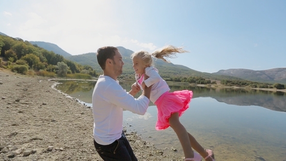 Father Whirls His Daughter Near The Lake