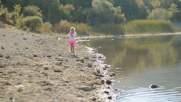 Little Cute Girl Running Along The Lake Near The