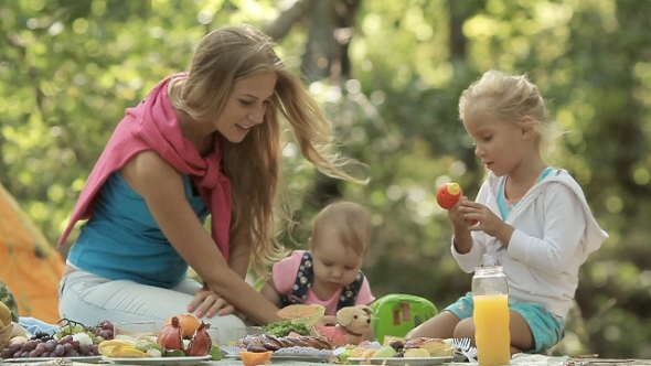 Young Mother And Little Daughter Playing With Baby