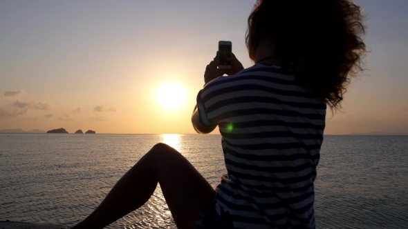 Woman Taking Pictures With Smartphone At Sunset