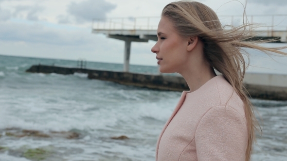 Happy Girl In a Pink Coat Near The Sea 